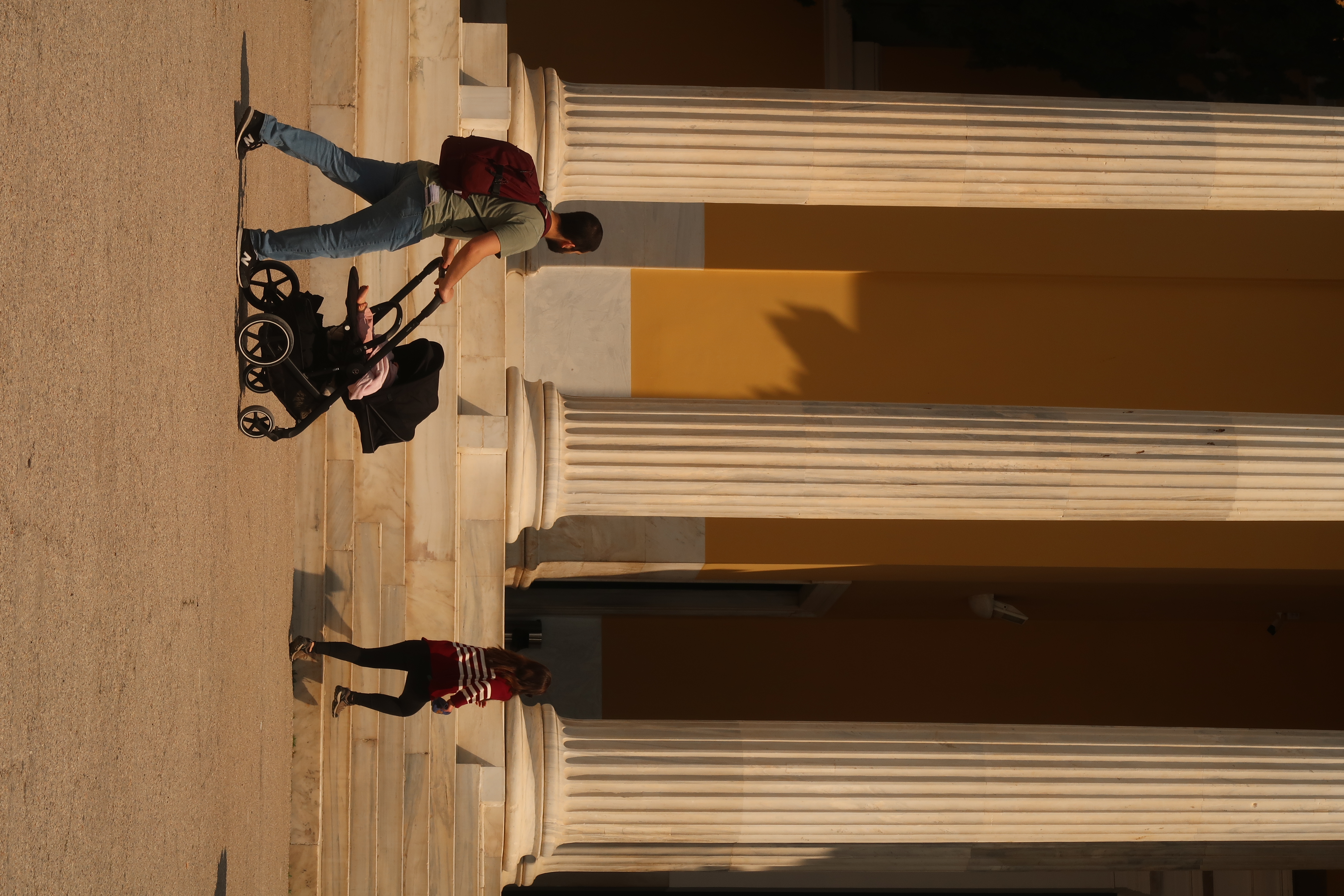 Marble entablature and shuttered doorway in raking sun