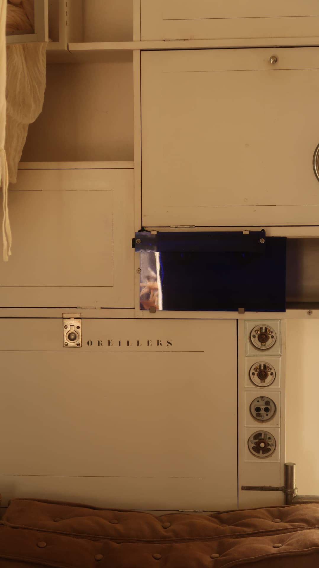 Cream cabinet fronts stencilled OREILLERS with cobalt glass panel