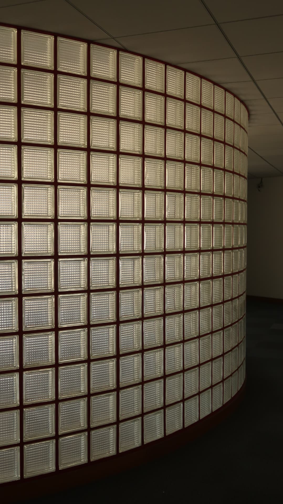Curved glass block wall with red mortar joints