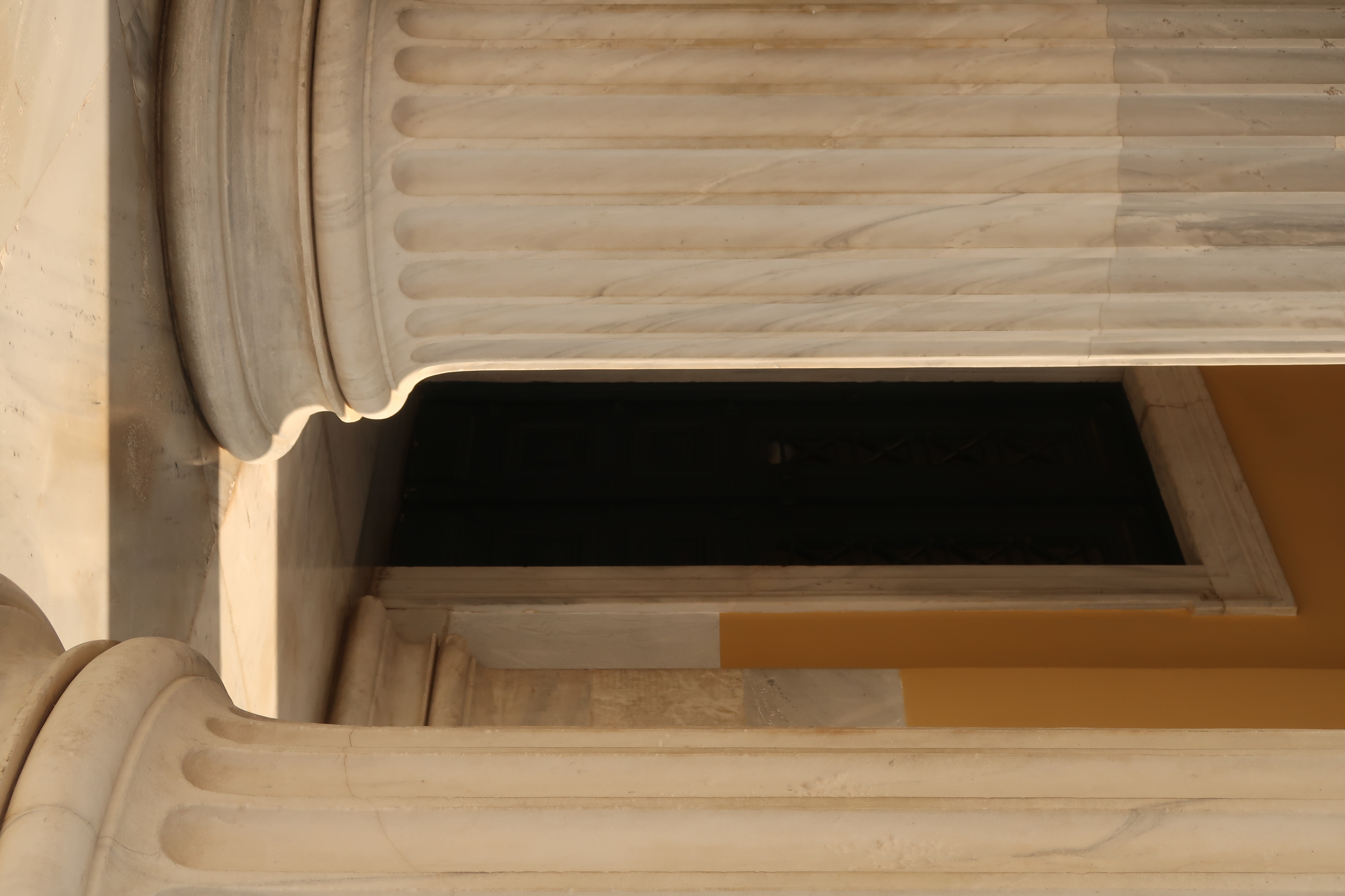 Fluted marble columns of a neoclassical portico in warm afternoon light