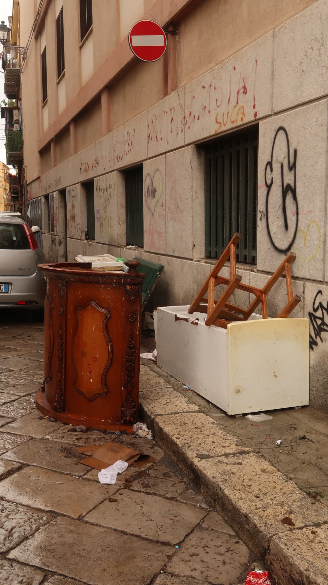 Discarded furniture left on a graffitied street corner