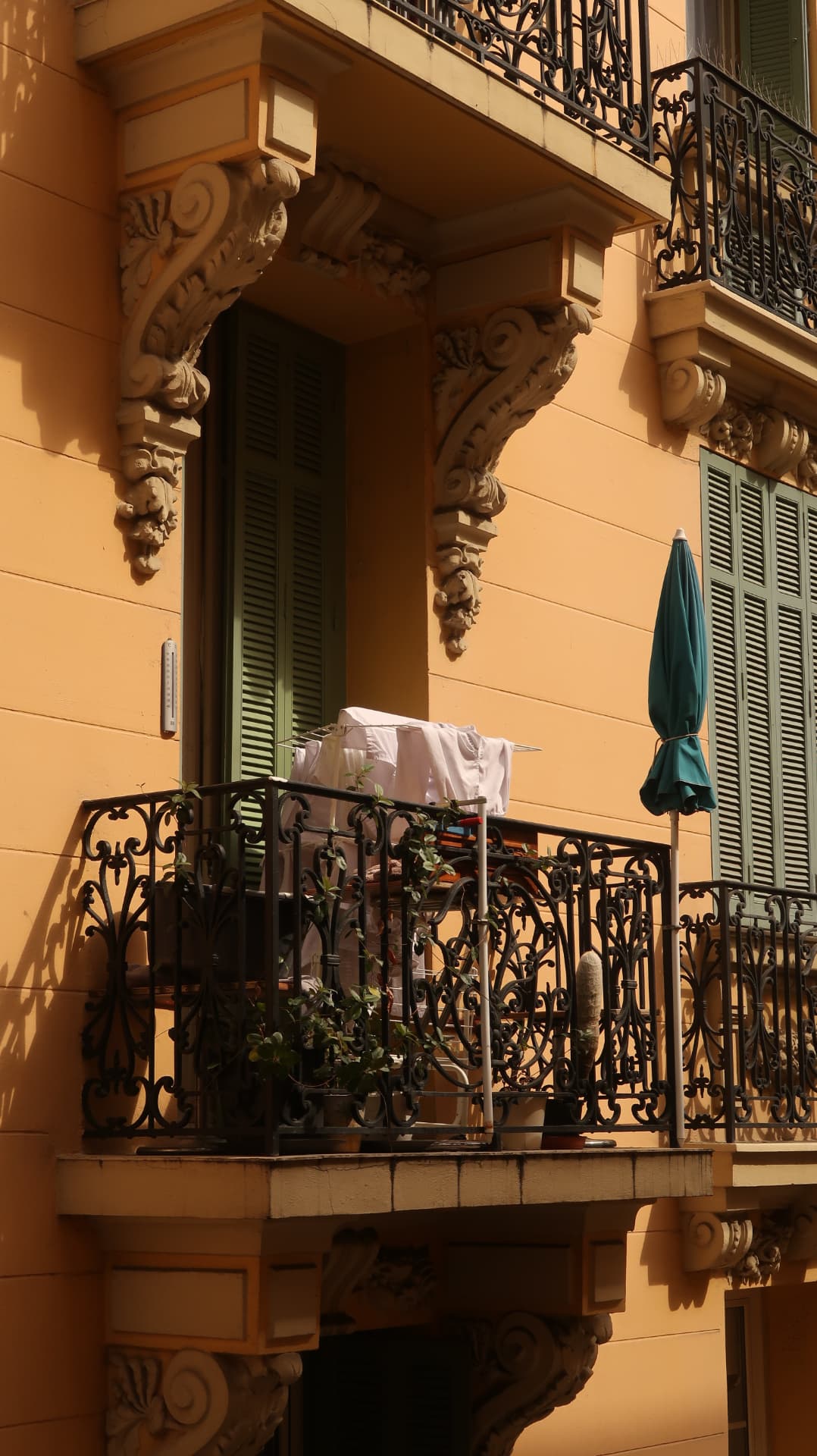 Ochre facade with iron balcony and drying laundry