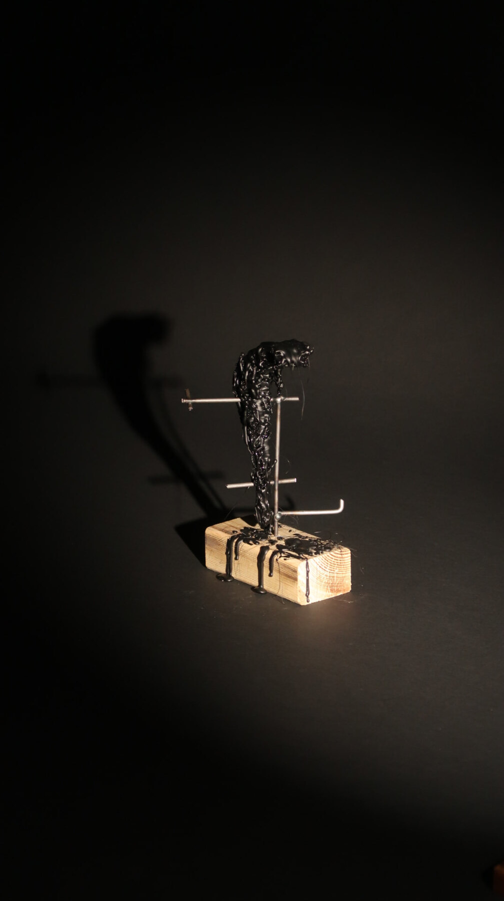 Model of a black resin mast on pins above a timber block