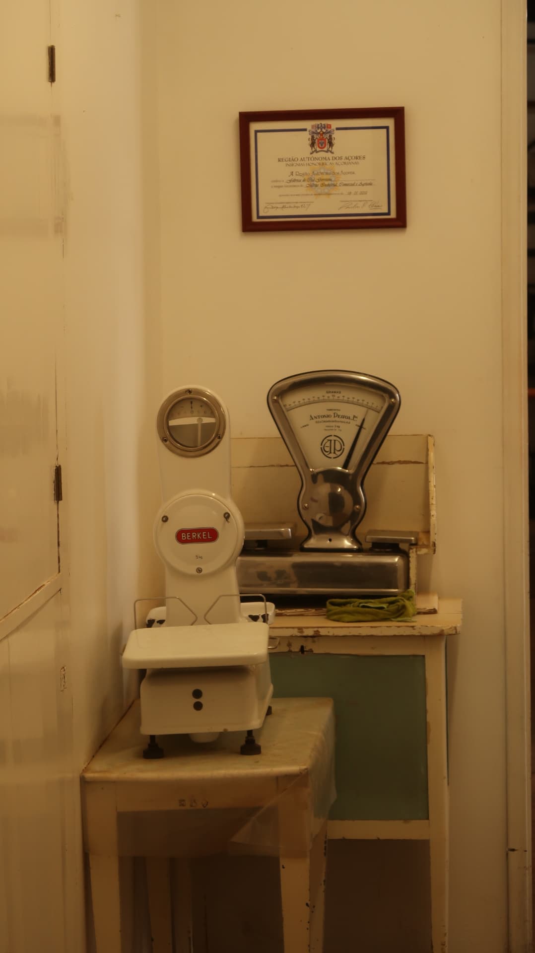 Two vintage shop scales beneath a framed certificate