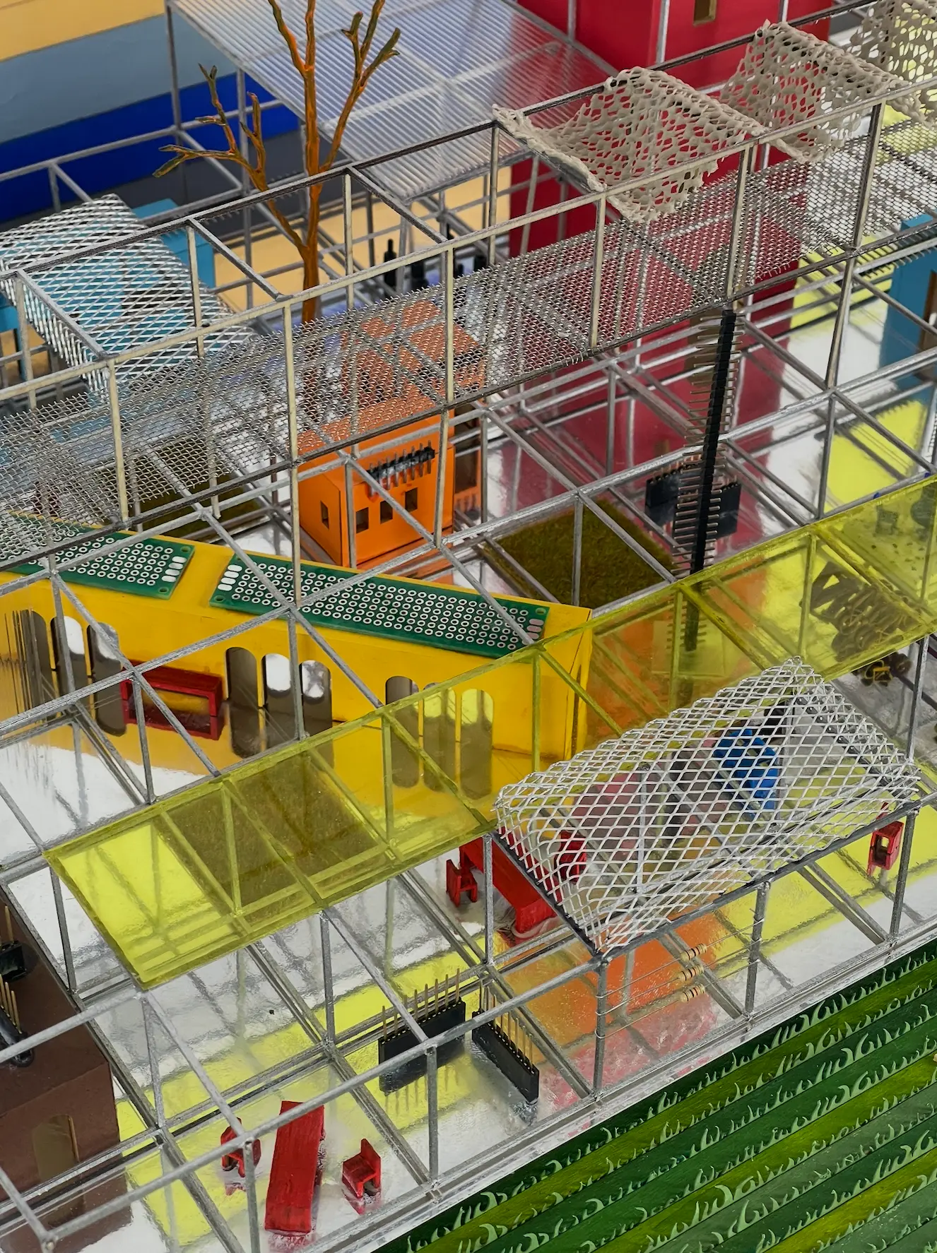 Close detail of the model's scaffold bays, transparent panels and green ground