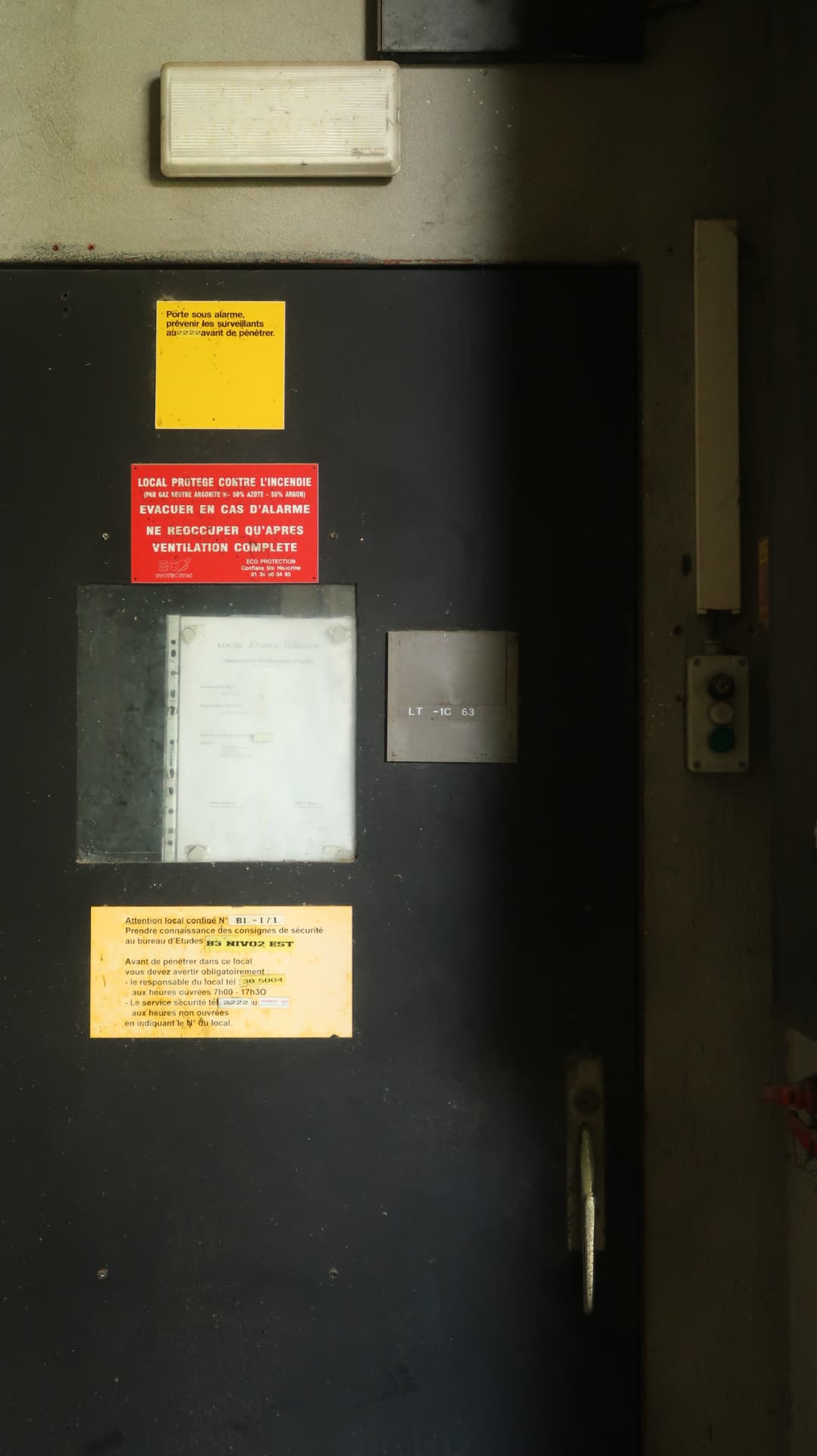 Service door layered with safety notices and signage