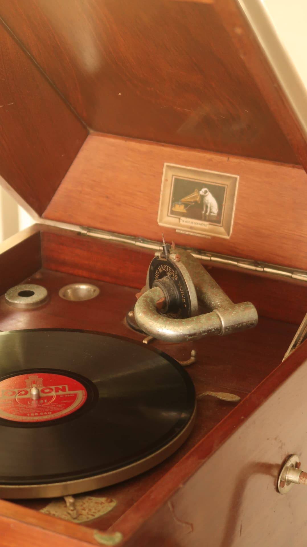 Open wooden gramophone with a shellac record on the platter