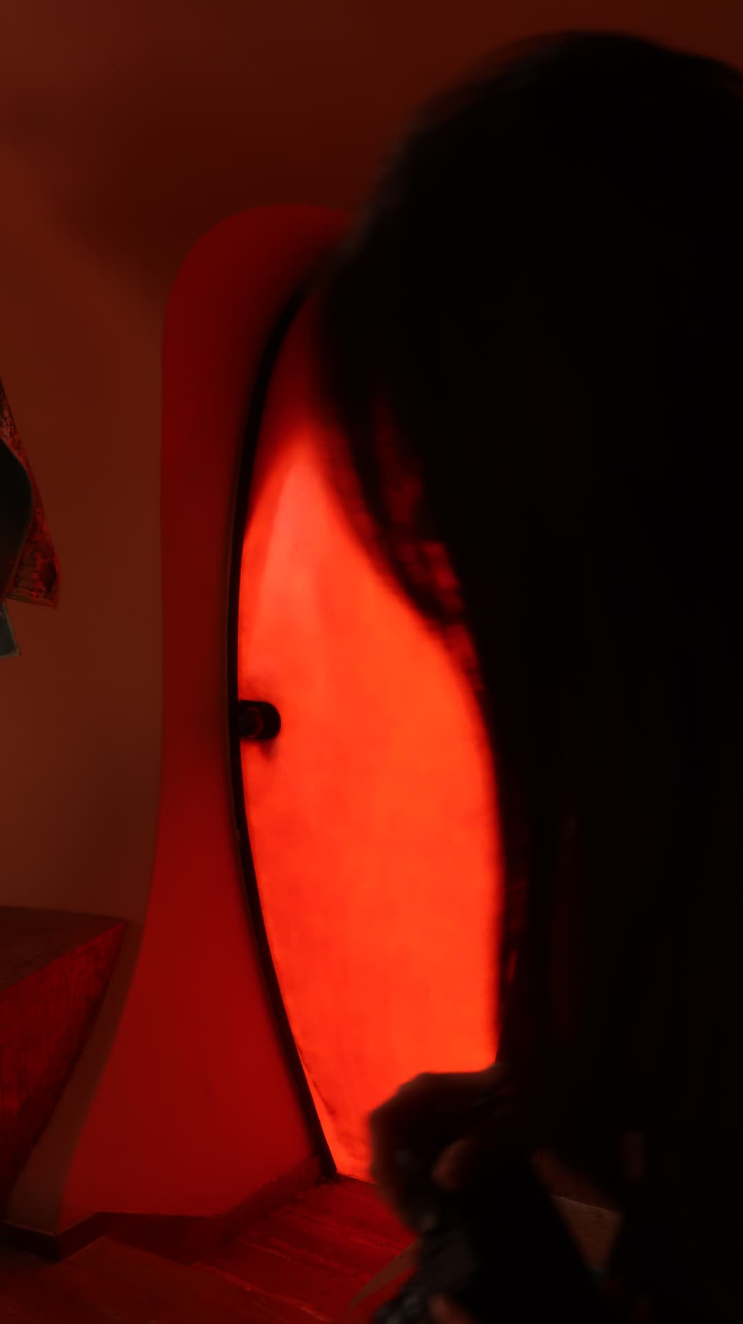 Silhouette before a glowing red oval doorway