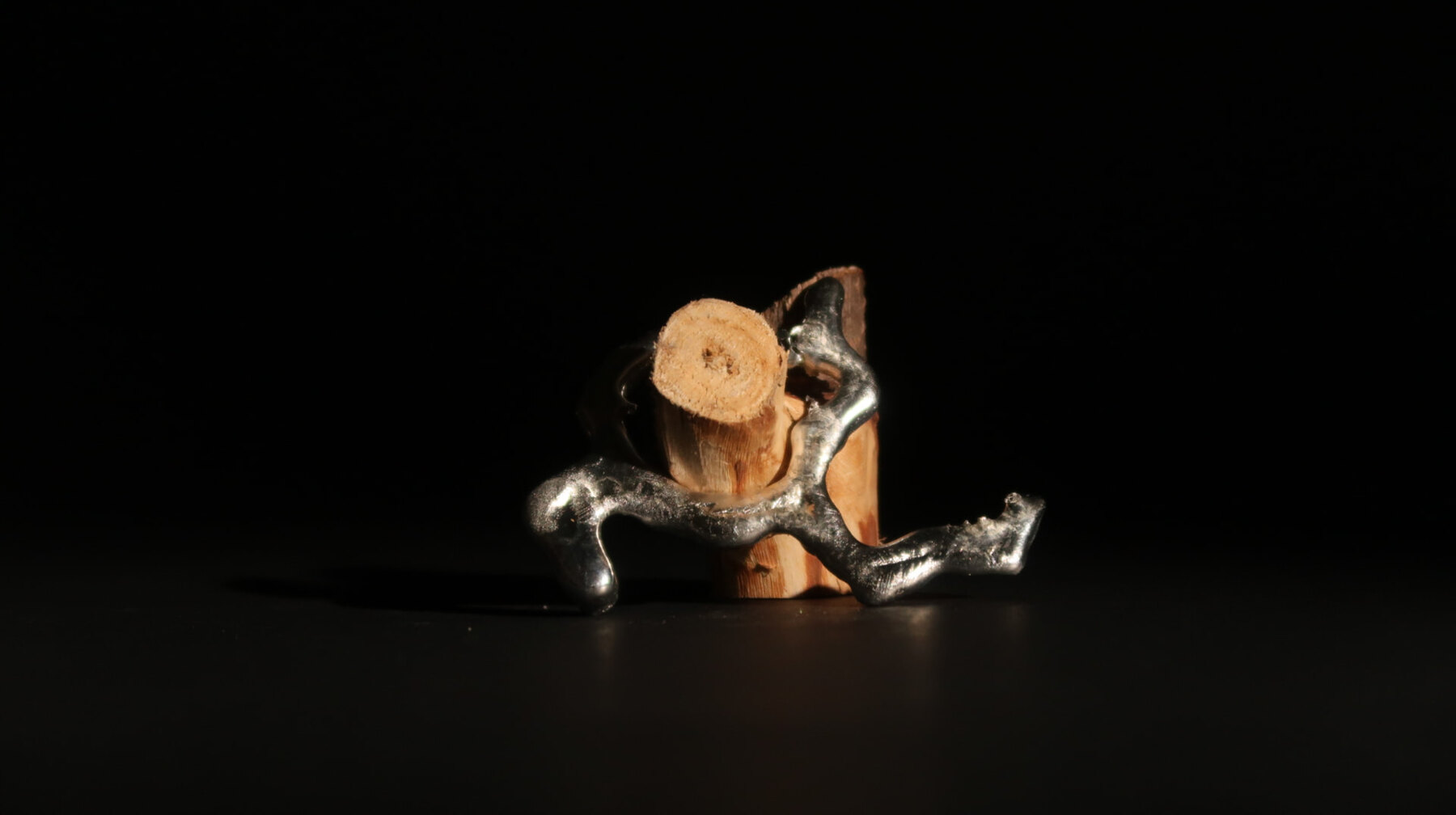 Standing model of a metal limb supporting a cut log