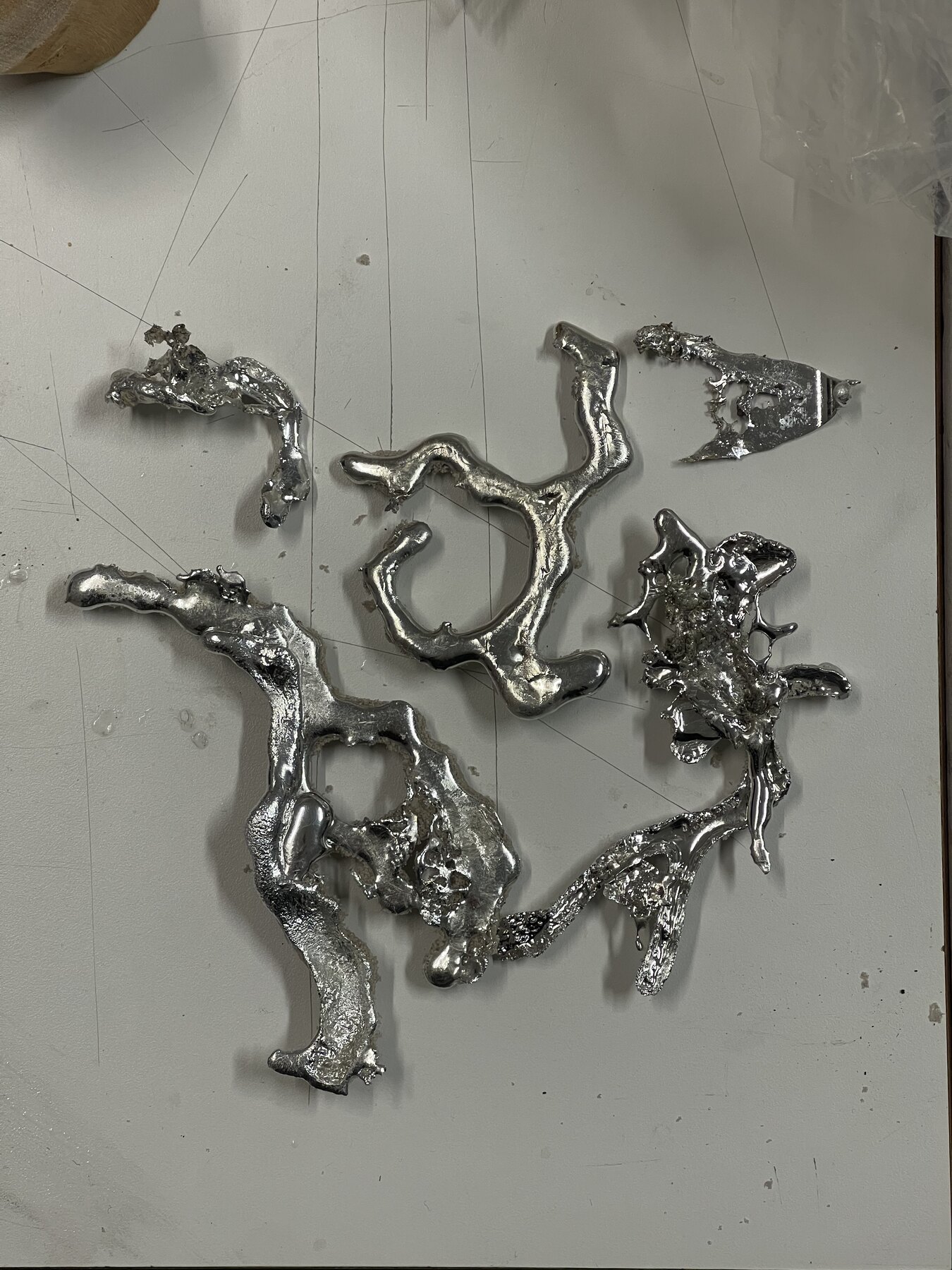 Five cast metal fragments arranged on the studio worktop